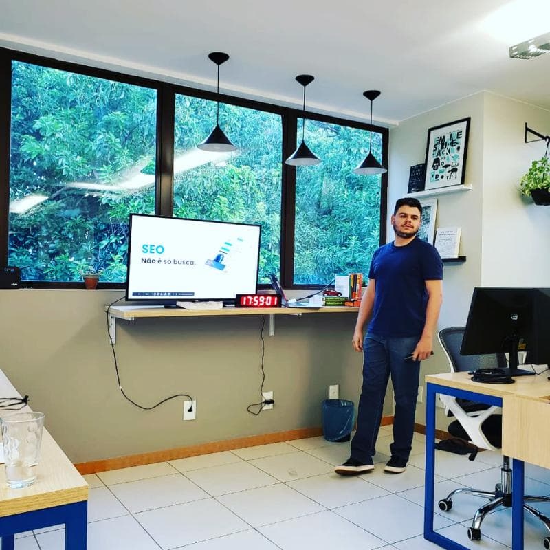 Raphael apresentando ao lado de uma tela sobre SEO